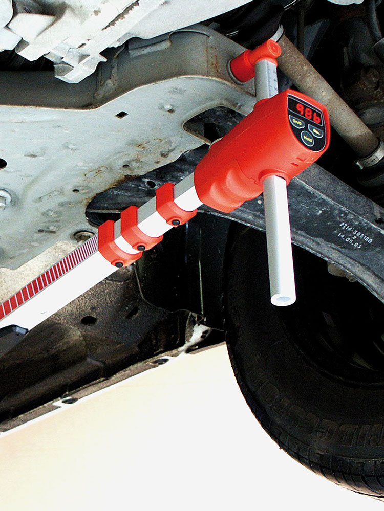 Allvis Light is mounted with its magnet to a car body. The measuring system is red and the display shows the numbers 986