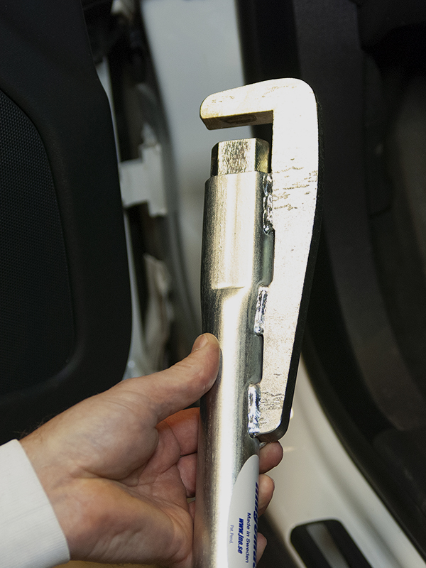 Hand som håller i Hingemaster. I bakgrunden syns dörren på en vit bil.